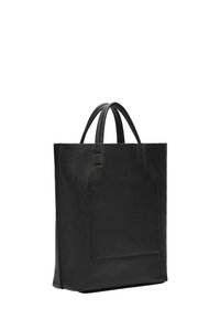 Zwarte leren tote bag met twee handgrepen, gestructureerde vorm, textuur op het oppervlak en een detail met een voorkant vak. Minimalistisch ontwerp zonder zichtbare hardware.