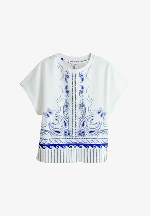 White short-sleeve top with blue paisley and wave patterns, featuring a round neckline and vertical stripes along the bottom hem.