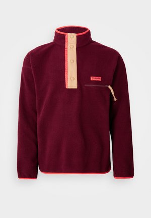 Burgundy fleece pulóver magas gallérral, krémszínű gombos pánttal, cipzáros mellzsebbel és kontrasztos narancssárga díszítéssel.