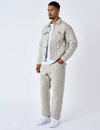 Mænds mønstrede jakke og bukser i lys beige, med geometriske designs, knaplukning foran og to brystlommer. Kombineret med hvide sneakers.
