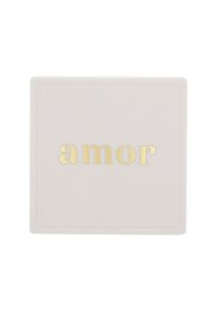 Objeto cuadrado de color rosa pálido con una superficie texturizada, que presenta la palabra "amor" en letras doradas en relieve en el centro.