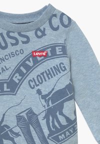 Lichtblauw sweatshirt met donkerblauwe grafische print, ronde hals, geribde manchetten en een klein rood Levi's logo label.