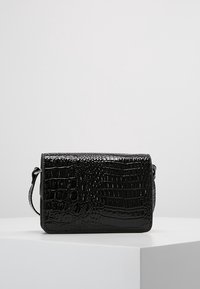 Borsa a mano nera in ecopelle con texture a coccodrillo, forma rettangolare e tracolla removibile. Presenta una finitura lucida.
