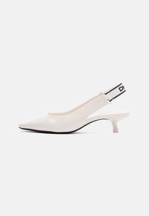 Scarpa slingback in vernice bianca con punta affilata, tacco kitten basso e cinturino elastico brandizzato bianco e nero sul tallone.