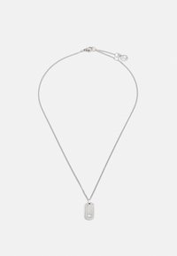 Collana argento con una catena sottile e un ciondolo a forma di dog tag rettangolare, dotato di una superficie testurizzata e di un piccolo accessorio pendente.