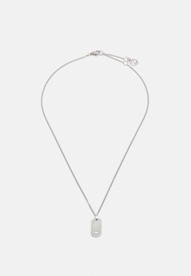 Collana argento con una catena sottile e un ciondolo a forma di dog tag rettangolare, dotato di una superficie testurizzata e di un piccolo accessorio pendente.