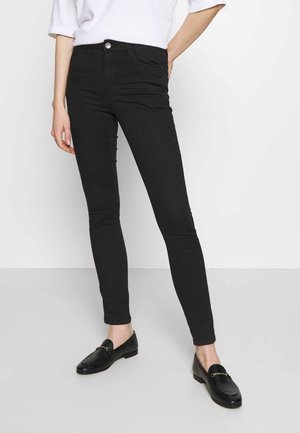 Black skinny jeans made of denim, featuring a mid-rise waist, five-pocket design, and a single button closure. Smooth texture, minimal detailing.