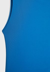 Top azzurro senza maniche realizzato in tessuto leggero e liscio. Presenta un design senza maniche con un collo arrotondato e bordi cuciti in modo pulito.