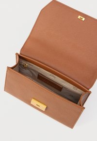 Bruine leren portemonnee met een textuur en gouden accenten, voorzien van een ritsvak en binnenvakken voor kaarten. Open ontwerp toont de binnenvoering.