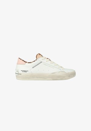 Sneaker bianca basse con suola beige, linguetta sul tallone rosa, fodera interna con stampa leopardo, cuciture a zigzag nere e testo "DISTRESSED WITH NO STRESS."