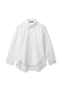 Camicia bianca a maniche lunghe con bottoni, colletto e orlo asimmetrico, adagiata su uno sfondo bianco.