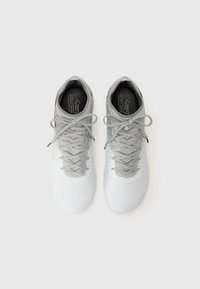 Chaussures de sport à lacets en blanc et gris clair, avec un revêtement texturé, un bout rond et un col rembourré pour le confort.