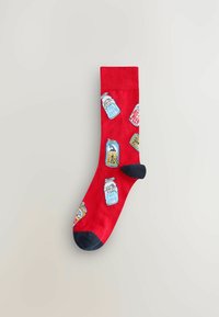 Rote Baumwollsocke mit einem Muster aus illustrierten Getränkedosen in Blau, Weiß und Gelb, mit schwarzen Akzenten an Ferse und Zehen.