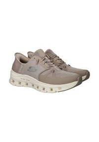 Beige Sport Schuhe mit einem Mesh-Obermaterial, ausgestattet mit einem gepolsterten Kragen, Schnürverschluss und einer gepolsterten Sohle mit sichtbaren Ausschnitten.