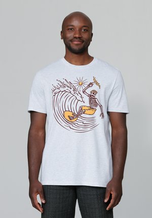 Grijze katoenen T-shirt met een skelet dat surft op een gele surfplank, omringd door golven en een zon, met bruine en gele accenten.