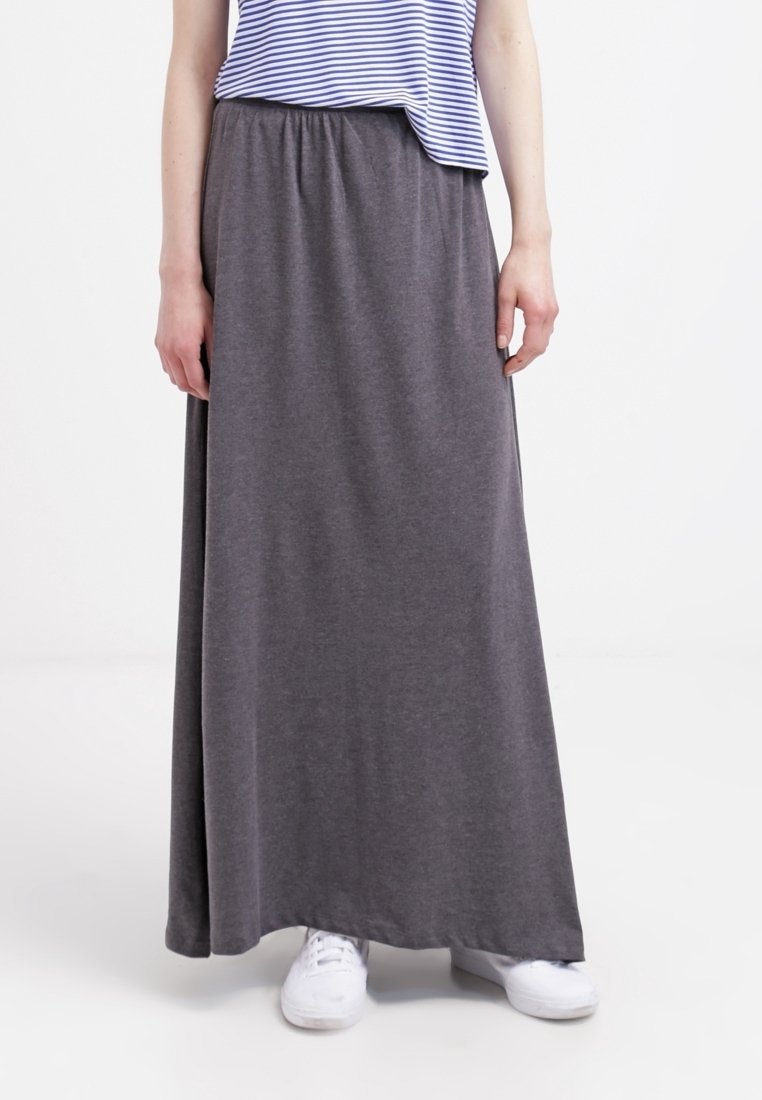 Gonna maxi grigia realizzata in tessuto morbido, con vita elastica. Abbinata a una maglietta a righe blu e bianche e scarpe da ginnastica bianche.