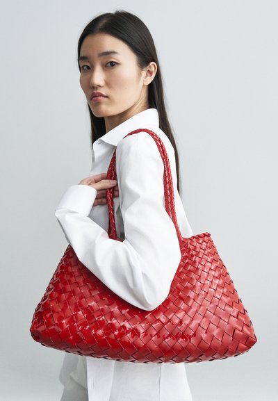 Saco tote de trama vermelha feito de material brilhante, apresentando duas alças torcidas e uma forma oversized e descontraída. Textura suave com um brilho subtil.