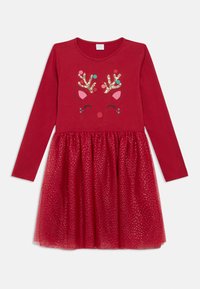 Rdeča obleka z dolgimi rokavi, ki prikazuje obraz severnega jelena z rogovji, rožnatimi ušesi in zlato svetlečimi detajli. Krilo iz tila s zlatim pikastim vzorcem.