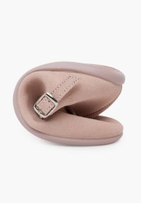Zapatilla de ante suave en un tono rosa pálido, con forma redondeada, suela plana de goma y hebilla ajustable de plata en una correa. Forro interior texturizado.