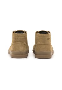 Stivaletti alla caviglia in suede beige con una texture liscia, suola in gomma e dettagli di cucitura discreti. Logo in rilievo sul lato esterno.