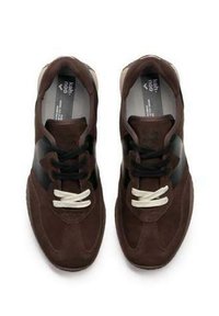 Sneaker in suede marrone con striscia nera accentata, punta tonda e lacci bianchi, dotate di una suola testurizzata per una buona aderenza e durata.