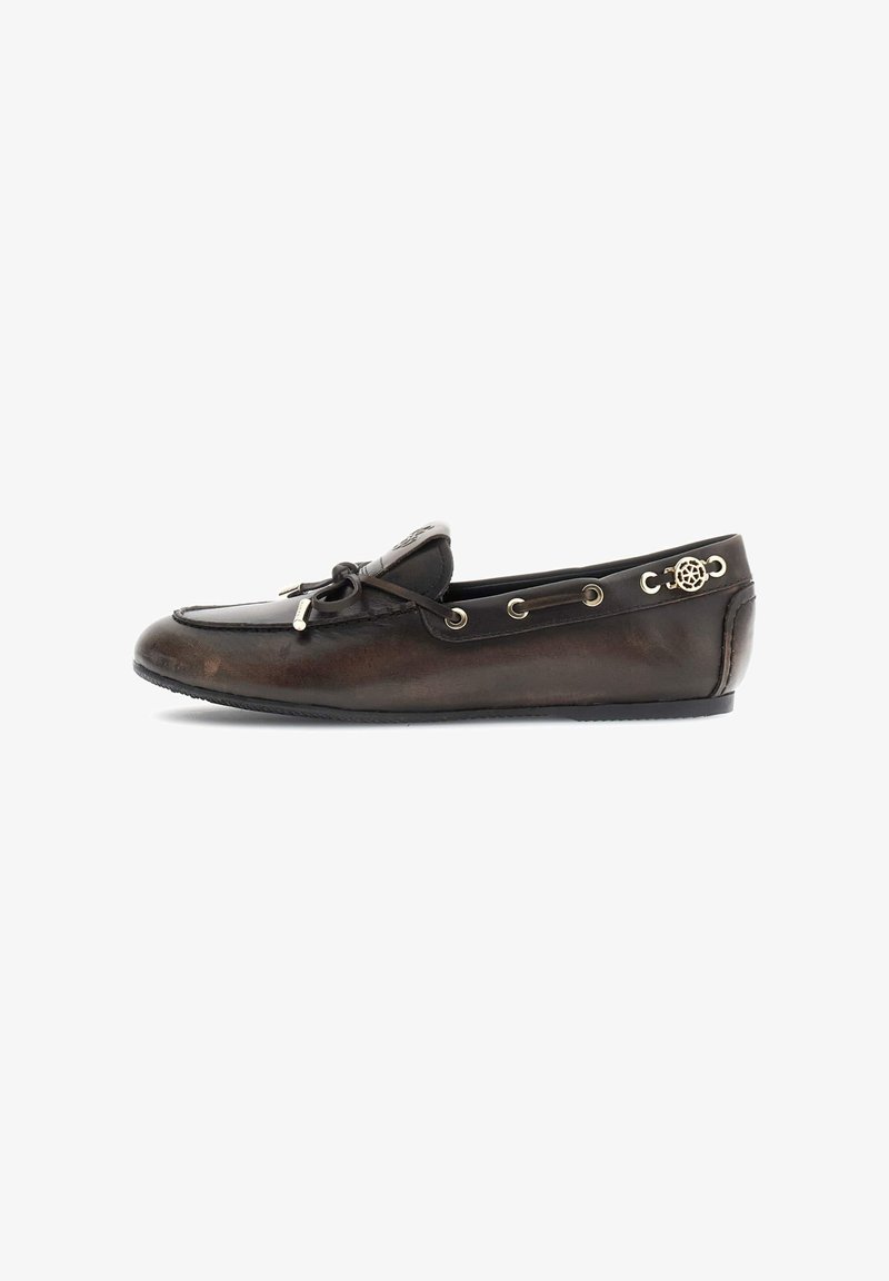 Mocassin en cuir marron foncé avec détail de lacet et emblème métallique sur le côté, semelle plate et design d'orteil cousu.