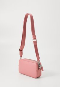 Rosa rektangulär crossbody-väska med dragkedjestängning, justerbar textilrem, slät yta och silverfärgade detaljer.