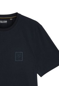 Navy katoenen T-shirt met een ronde hals en korte mouwen, met een tonale adelaar logo binnen een vierkant op de borst.