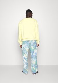 Karl Kani SMALL SIGNATURE WASHED CREW UNISEX - Sportska majica - light yellow