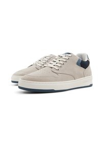 Suede sneakers in light gray with a white midsole and dark blue heel accent. Features round laces and perforated detailing on the toe.