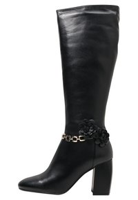 Czarny, skórzany kozak za kolano z szpiczastym noskiem i masywnym obcasem. Ozdobiony kwiatowym akcentem i złotym łańcuszkiem przy kostce. Gładka faktura.