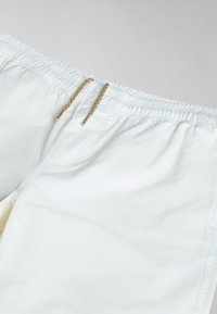Witte katoenen shorts met een elastische tailleband en gouden hardware trekkoorden, een gladde textuur en zijzakken.