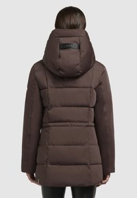 Brown puffer jacket with a hood, featuring quilted sections and a logo tag on the back. Smooth texture, knee-length design, and fitted sleeves.