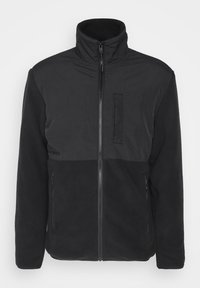 Svart jakke med høy krage; har glatt ytterstoff og fleece i nedre del; inkluderer frontglidelås og sidelommer.
