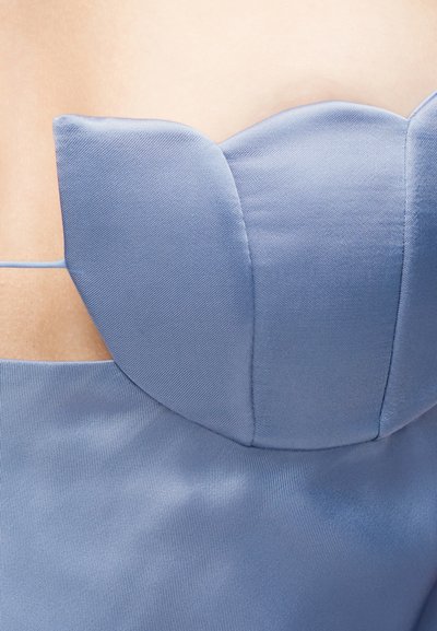 Κοντινό πλάνο ανοιχτό μπλε σατέν φόρεμα χωρίς τιράντες με δομημένο ντεκολτέ σε σχήμα καρδιάς και πλαϊνή λεπτομέρεια με άνοιγμα.