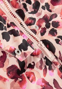 Tissu imprimé léopard en rose et noir avec une texture lisse. Comprend une fermeture éclair de couleur claire et des boutons-pression en argent.