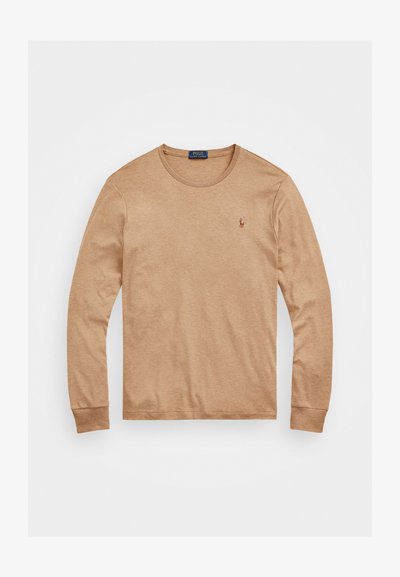 Garās piedurknes, gaiši brūnas kokvilnas T-krekls ar apaļu izgriezumu un ribotām aprocēm; tam ir neliels izšūts logotips uz krūšu daļas.