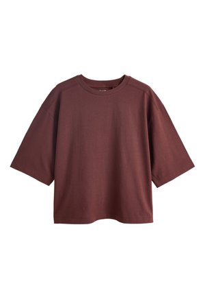 T-shirt coupe boxy, manches courtes, col rond, marron foncé uni avec épaules tombantes sur fond blanc.