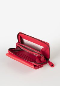 Portafoglio in pelle rossa con chiusura a zip attorno, diversi scomparti per carte e un piccolo vano con zip all'interno. Texture liscia e design strutturato.