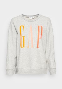 Felpa grigia con un logo "GAP" colorato in gradiente arancione e rosa. Collo a giro e maniche lunghe con polsini a coste.