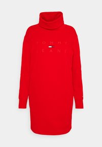 Vestido rojo de manga larga tipo cuello alto con un corte holgado, que presenta el logo "TOMMY JEANS" en costura blanca en el frente y cuello de canalé.