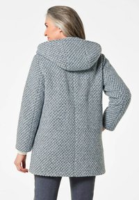 Gepolsterter grauer Mantel mit Kapuze, aus strukturiertem Stoff, langen Ärmeln und geradem Schnitt, entworfen für Wärme und Komfort.