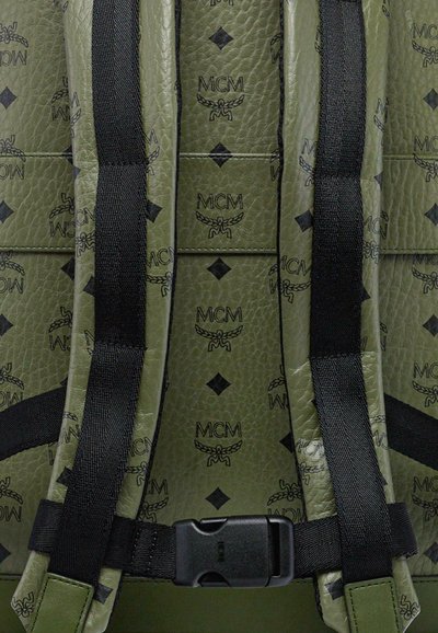 Zaino verde in pelle con motivo in logo MCM nero, dotato di spallacci imbottiti e una fibbia nera per una chiusura sicura. Superficie testurizzata.