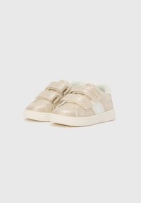 Adidași sclipitori aurii cu două curele reglabile cu Velcro, accente albe, vârf rotund și suprafață texturată. Talpa exterioară crem.