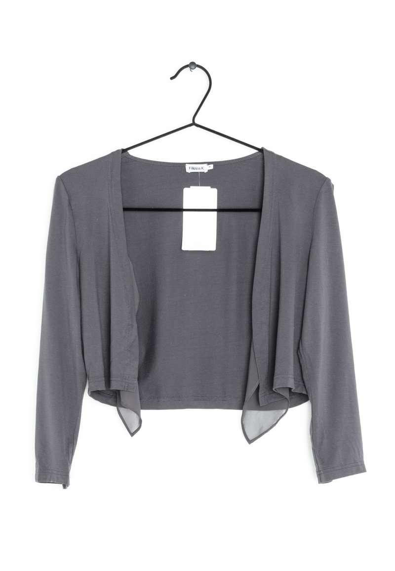 Šedý zkrácený kardigan s dlouhými rukávy, měkkou texturou, otevřeným designem vpředu a připevněnou štítkem, visící na černém háčku.