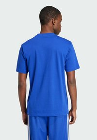 Blue cotton t-shirt with a crew neck and short sleeves, shown from the back. Smooth texture with no visible patterns or accents.