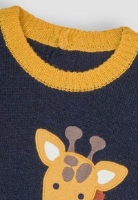Marineblauer Pullover mit einem gelben gerippten Kragen, der ein Giraffenapplikation in Gelb- und Brauntönen zeigt, mit strukturierten Details an den Ohren.