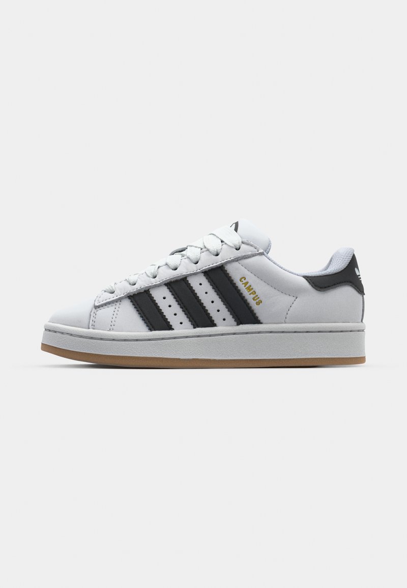Zapatillas de cuero blancas con tres rayas negras, cuello acolchado y suela de goma. Presenta la marca "CAMPUS" en el costado.