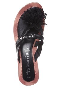 Tongs noires avec une tige en cuir texturé, pompon décoratif à franges et accents en strass sur la lanière, avec une semelle rose.