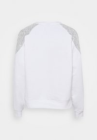 Vit sweatshirt med texturerade grå spetsdetaljer på axlarna, rundad hals, och ribbade ärmslut och nederkant. Mjuk tygkvalitet med en avslappnad passform.